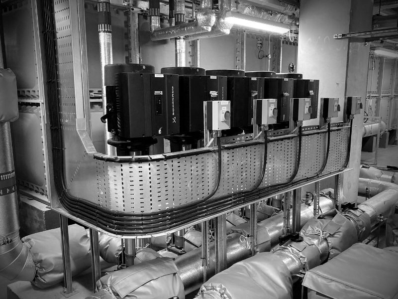A photograph showcasing Grundfos pumps. The image features a line-up of sleek and modern pumps, each displaying the distinctive Grundfos logo